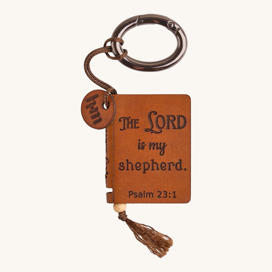 Holy Matters vegetable-tanned leather mini Bible keepsake keychain engraved with Psalm 23:1 and a decorative tassel.