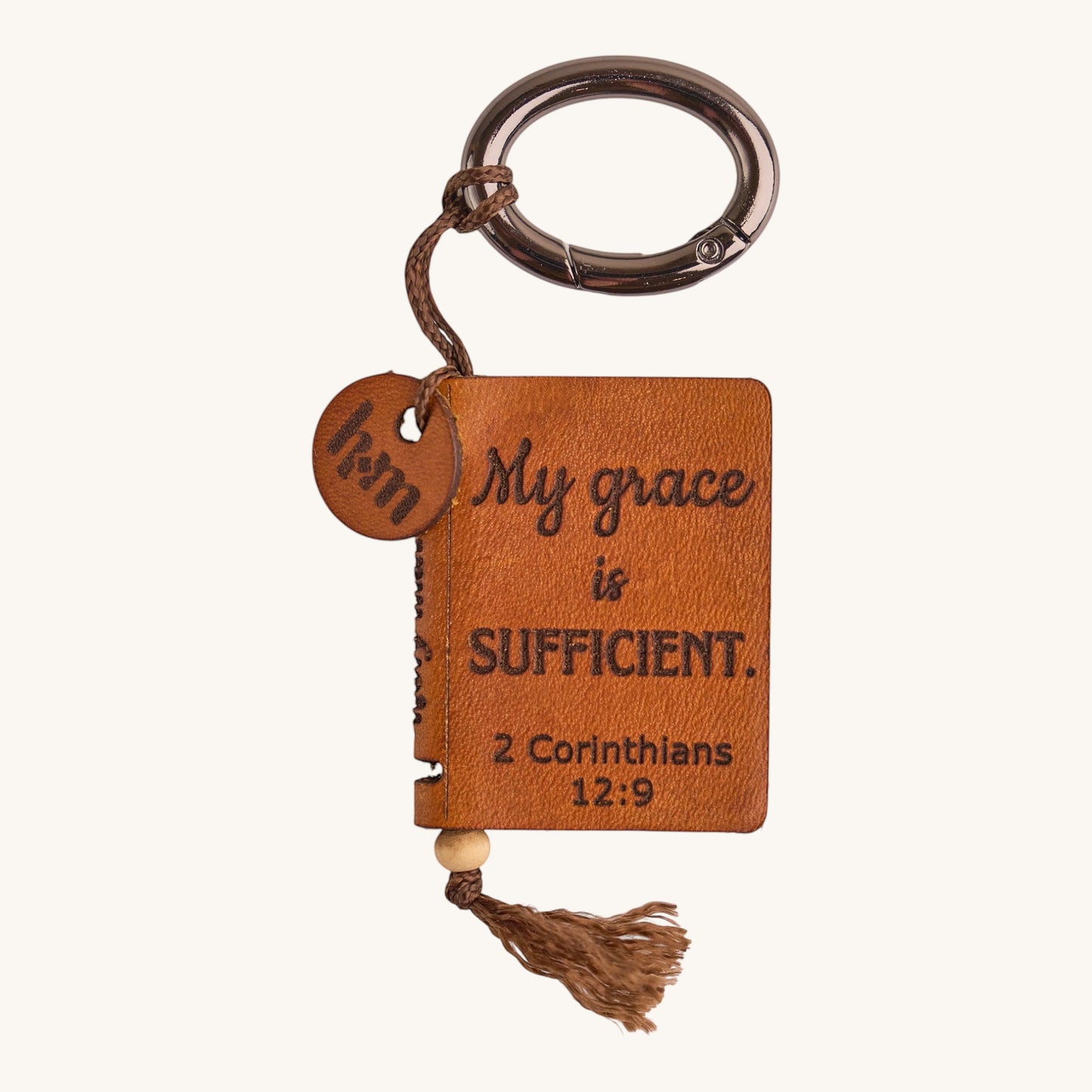 Holy Matters handcrafted vegetable-tanned leather mini Bible keepsake keychain with 2 Corinthians 12:9 scripture.