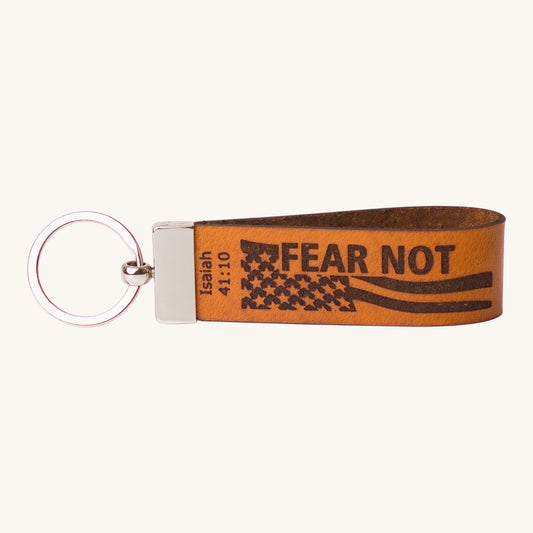 Holy Matters handcrafted vegetable-tanned leather keychain featuring Isaiah 41:10 Fear Not scripture and flag design.