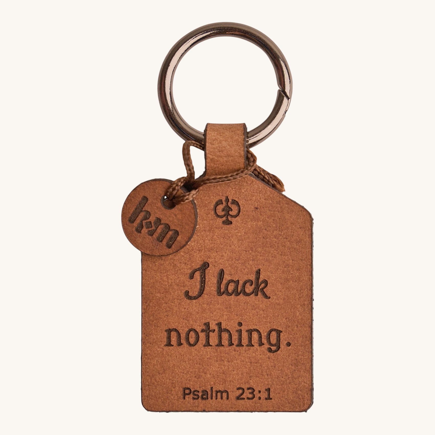 Holy Matters handcrafted vegetable-tanned leather keychain with Psalm 23:1 engraving and small logo charm.