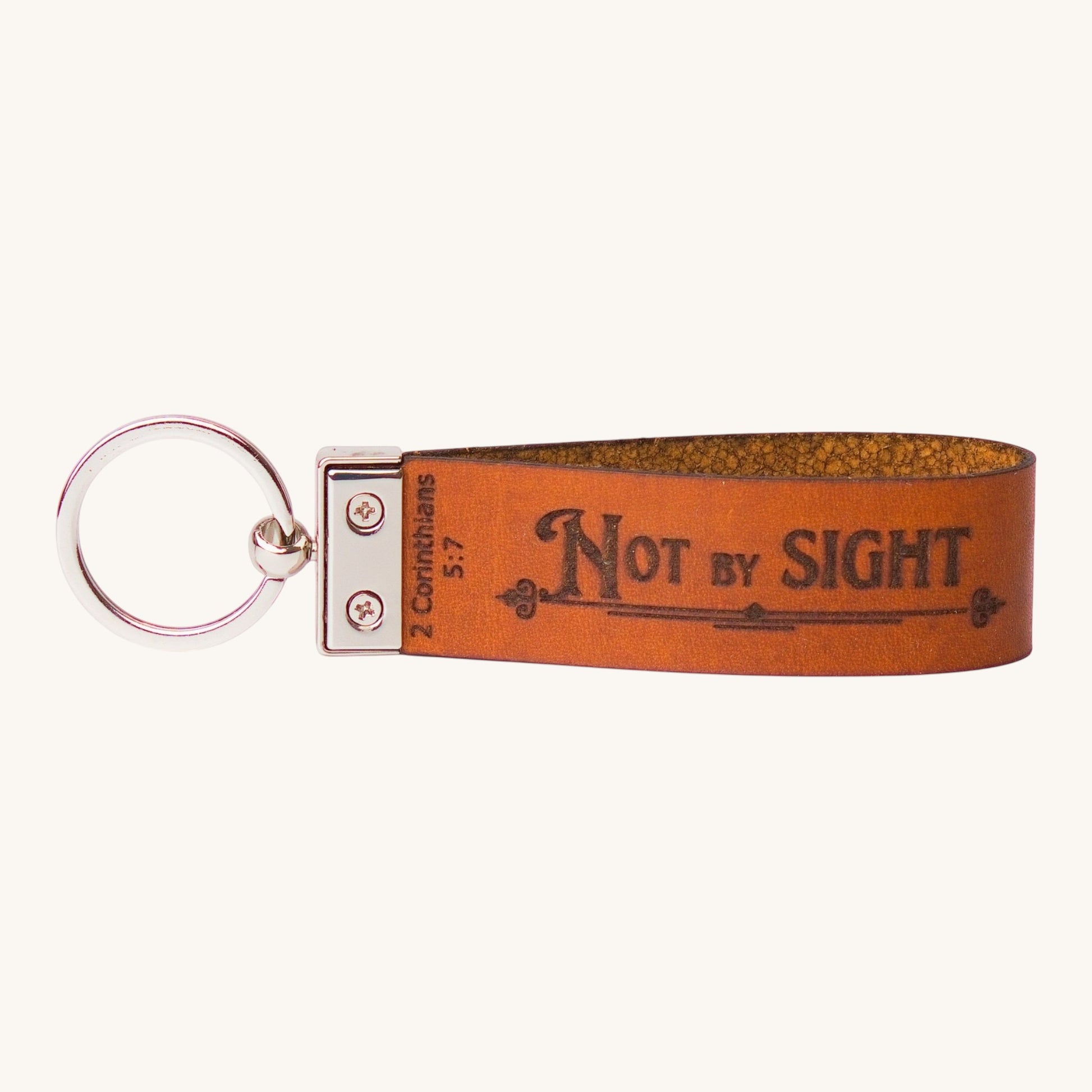 Holy Matters handcrafted vegetable-tanned leather keychain engraved with 2 Corinthians 5:7 Not by Sight scripture