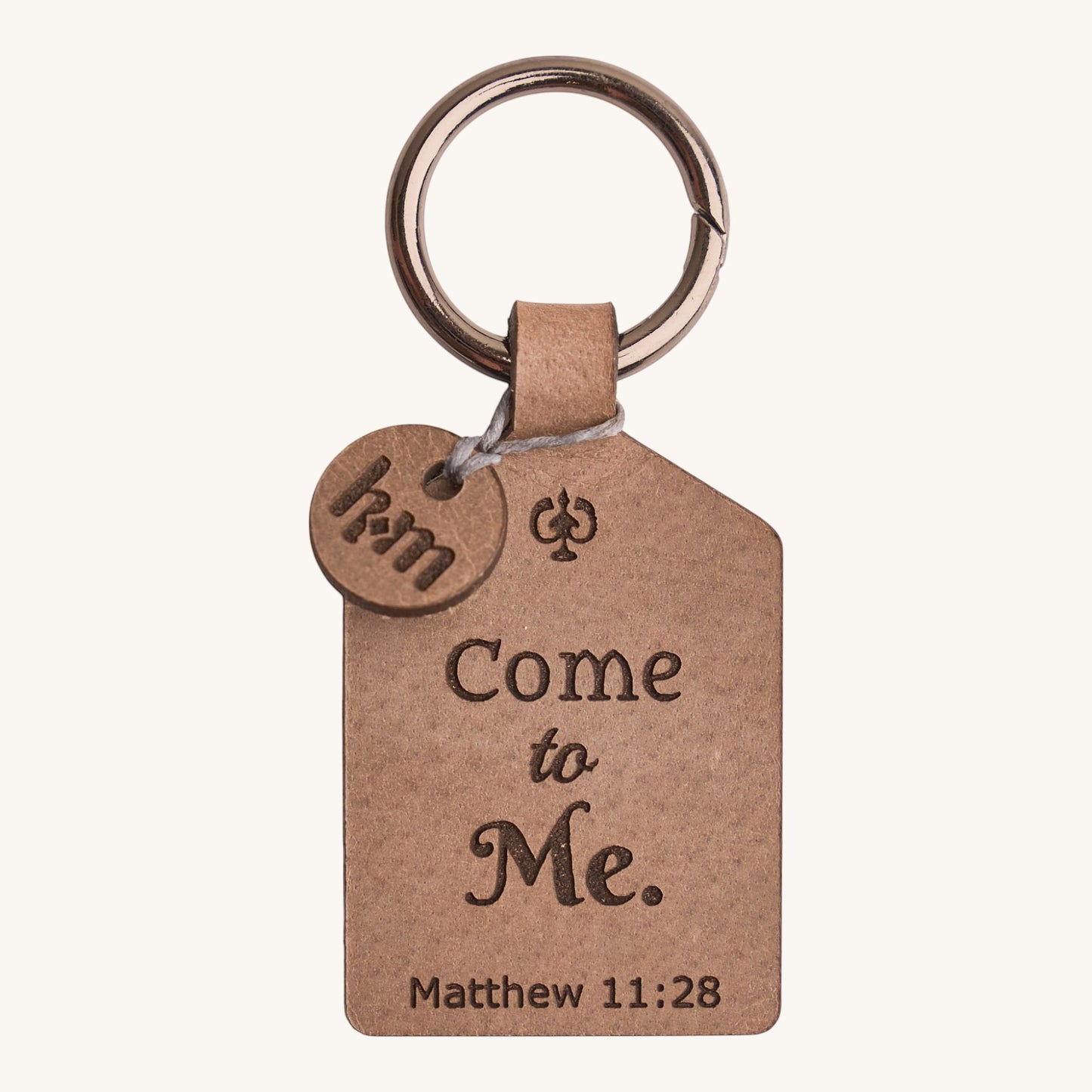 Holy Matters vegetable-tanned leather keychain engraved with Come to Me Matthew 11:28 scripture and a small HM charm.