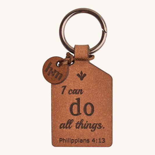 Holy Matters vegetable-tanned leather keychain engraved with Philippians 4:13 scripture and a small logo charm.