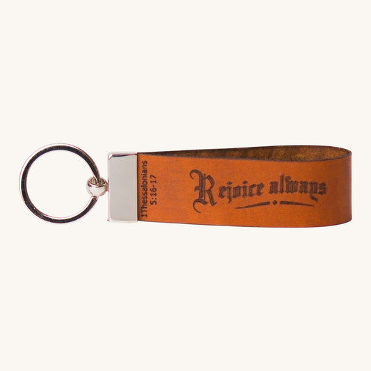 Holy Matters handcrafted vegetable-tanned leather keychain featuring Rejoice always and 1 Thessalonians 5:16-17 text.